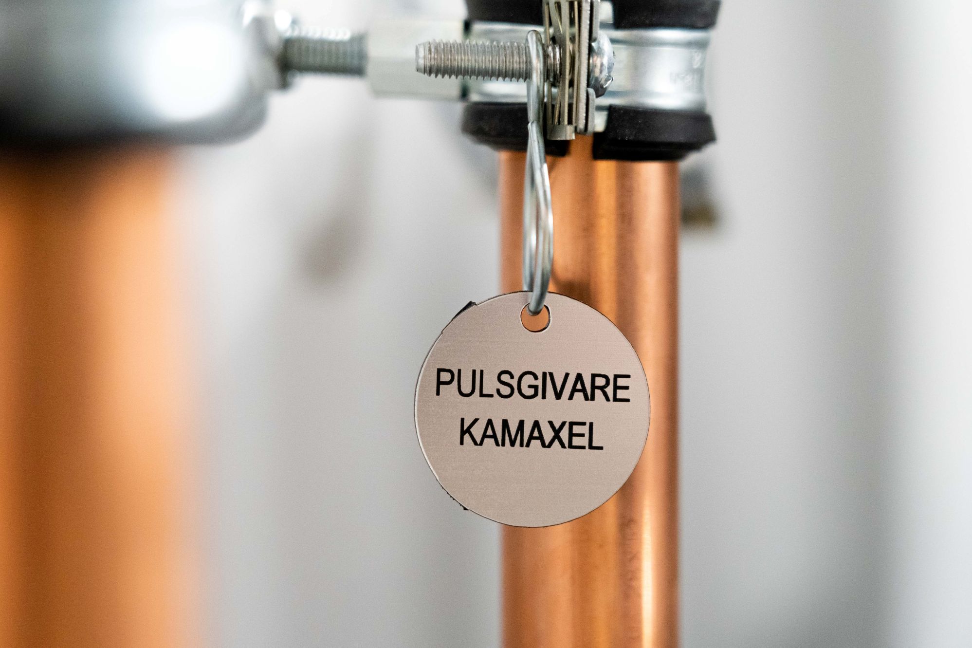 Ventilbrickor i rostfritt stål med lasergraverad text med texten pulsgivare kamaxel